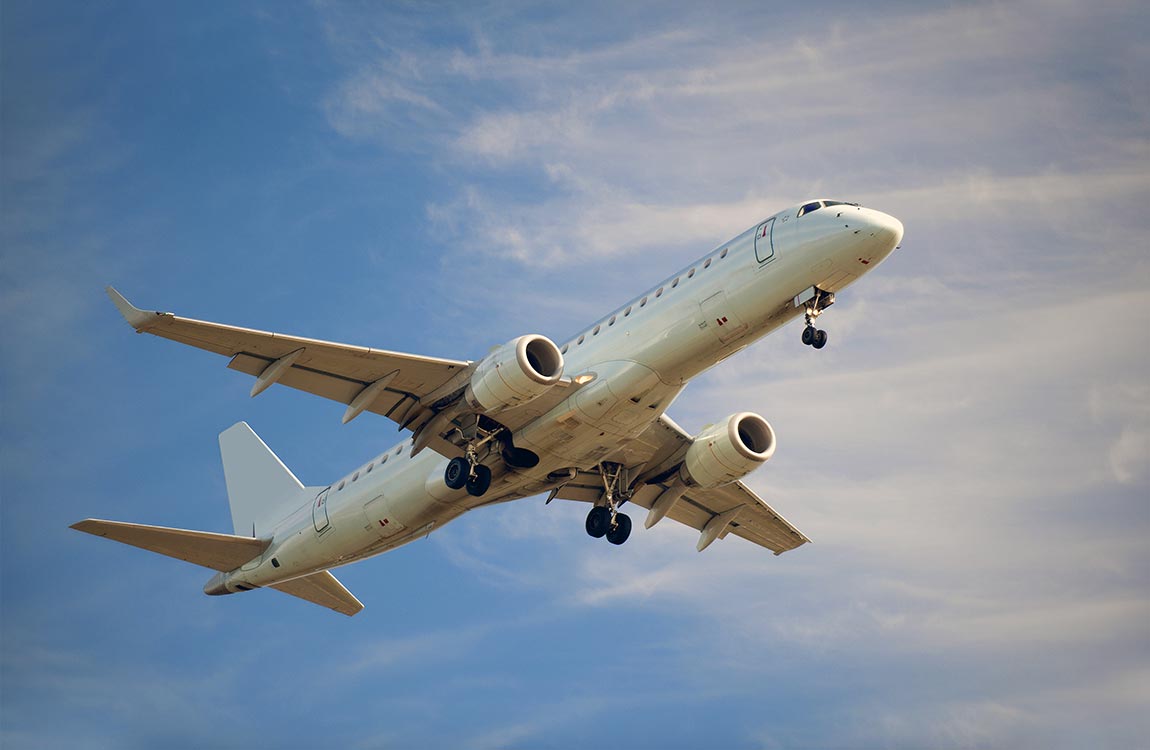 Regional jet aircraft after take off, with a blue sky and clouds 