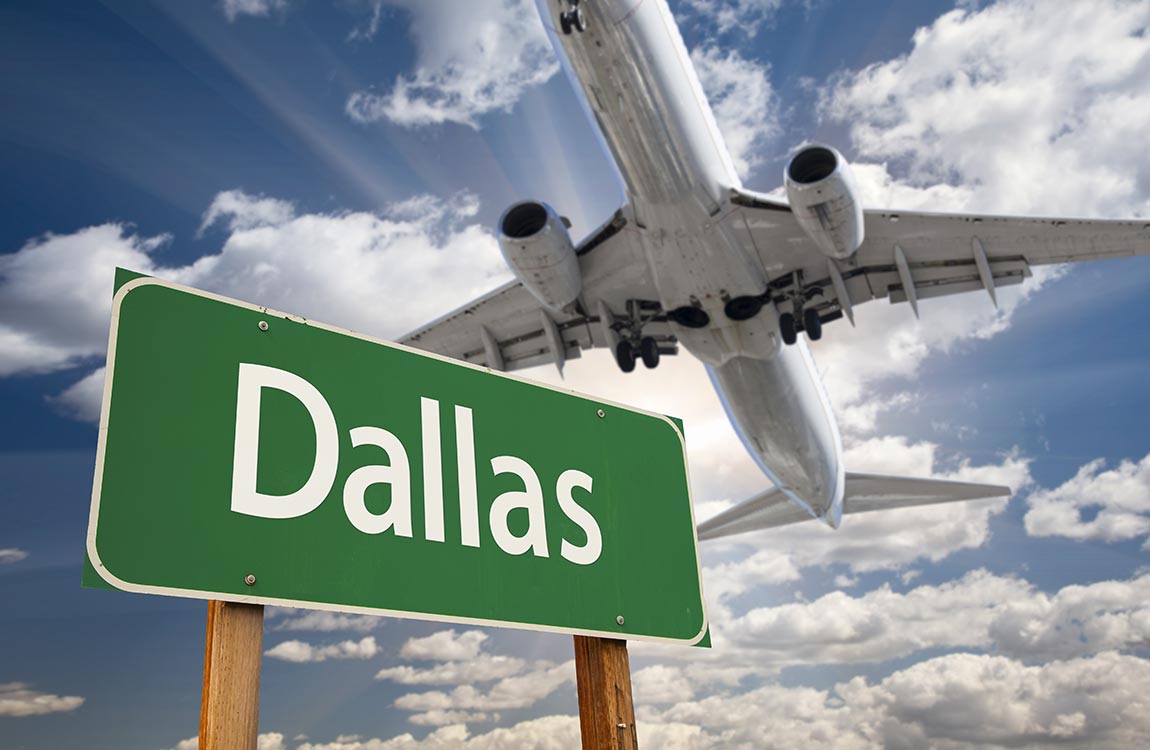 Airplane landing behind large sign that says "Dallas" 