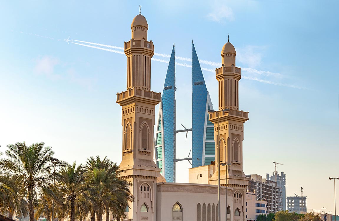 Photo of the Bahrain World Trade Centre, modern twin glass towers connected by three wind turbines 