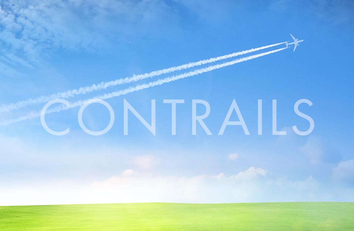 A beautiful blue sky above a lush green ground, with a small jet aircraft in the sky generating two long contrails 