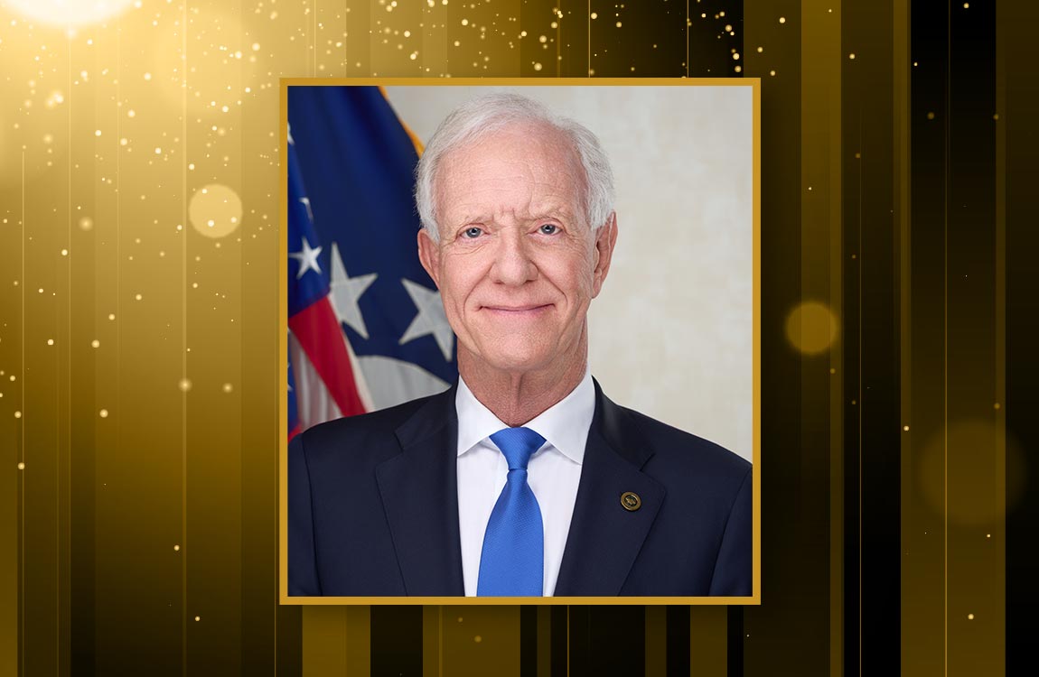 An official portrait of Captain Chesley "Sully" Sullenberger agains a celebratory background of gold colors 